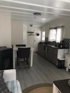 a kitchen and living room with a table and a kitchen and a kitchen at Chalet Het Wollinghuisje in Vlagtwedde