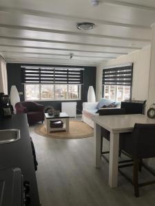 Sala de estar con cama y mesa en Chalet Het Wollinghuisje, en Vlagtwedde