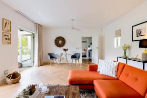 ein Wohnzimmer mit einem orangenen Sofa und einem Tisch in der Unterkunft Maison Cabrière - Boutique Suites in Franschhoek