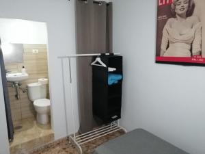 a bathroom with a toilet and a poster of a woman at Alcaravaneras Hostel in Las Palmas de Gran Canaria