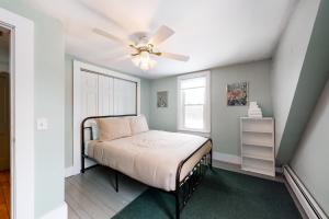 a bedroom with a bed with a ceiling fan at Pineapple Paradise in Stowe