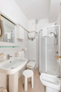 La salle de bains blanche est pourvue d'un lavabo et de toilettes. dans l'établissement Albergo La Sirenella, à Sperlonga