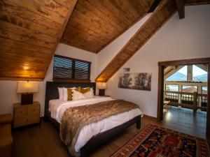 a bedroom with a bed and a wooden ceiling at Beautiful Views! Jacuzzi, Indoor/ Outdoor Fireplace, Steps to Lake Estes in Estes Park