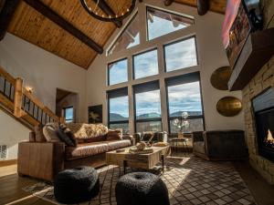 a living room with a couch and large windows at Estes Escape - Jacuzzi, Indoor Outdoor Fireplace, Perfect Location! in Estes Park