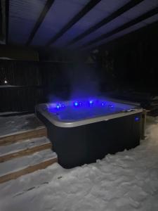 een bad met blauwe verlichting in de sneeuw bij Guesthouse Kärsämäki in Kärsämäki