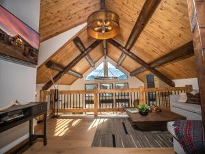 a living room with a vaulted ceiling with wooden beams at Estes Escape - Jacuzzi, Indoor Outdoor Fireplace, Perfect Location! in Estes Park