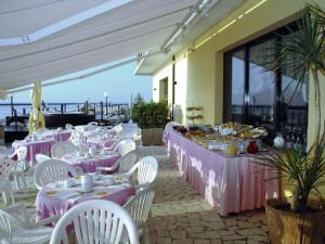 a group of tables with white chairs and pink tablecloths at Hotel Primavera sul mare in Lido di Savio