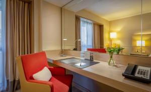 Cette chambre d'hôtel comprend un bureau et une chaise rouge. dans l'établissement InterContinental São Paulo, an IHG Hotel, à São Paulo