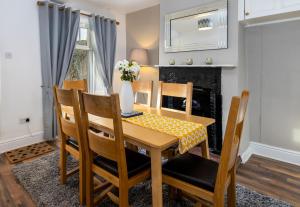 a dining room with a table and chairs and a fireplace at Muncaster Cottages in Ravenglass +9 photos