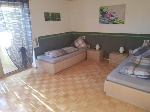 1 Schlafzimmer mit 2 Betten und Holzboden in der Unterkunft Apartment am Riegelberg in Oesdorf