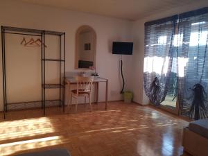 Zimmer mit einem Schreibtisch, einem Tisch und einem Fenster in der Unterkunft Apartment am Riegelberg in Oesdorf