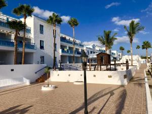 eine Straße mit Palmen vor einem Gebäude in der Unterkunft Aguazul 112, 118, 202, 216 in Puerto del Carmen