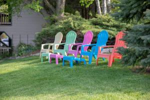 a group of colorful chairs sitting in the grass at Coachlite Inn in Sister Bay