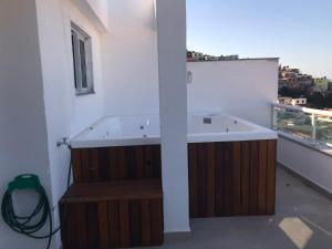 La salle de bains est pourvue d'une baignoire sur le balcon. dans l'établissement Cobertura Arraial do Cabo Fundos, à Arraial do Cabo 37 autres photos