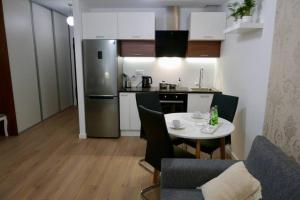 a small kitchen with a table and a refrigerator at Studio nr 1 close to Medicover and Paley Institute in Warsaw +3 photos