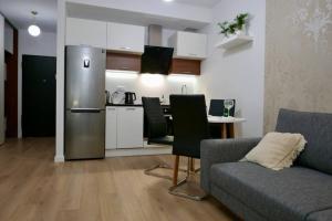 a living room with a couch and a kitchen at Studio nr 1 close to Medicover and Paley Institute in Warsaw