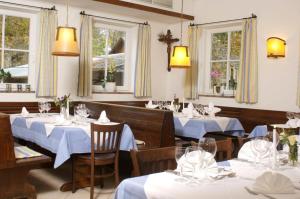 ディーセン・アム・アンマーゼーにあるHotel Gasthof Seefelder Hofの白いテーブルと椅子、窓のあるレストラン