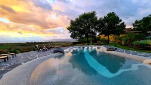 a swimming pool with a sunset in the background at Il Nido di Gabbiano in Scarperia