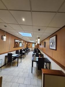 une salle à manger avec des tables et des chaises dans un restaurant dans l'établissement New Windsor, à Étretat