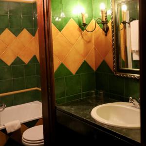 a bathroom with a sink and a toilet and a mirror at Hotel Portofoz in Porto