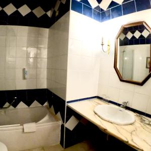 a bathroom with a sink and a tub and a mirror at Hotel Portofoz in Porto
