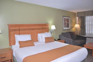 um quarto de hotel com uma cama grande e um sofá em Scottish Inns em DeSoto