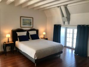 1 dormitorio con 1 cama grande y cortinas azules en Manoir 1685 Saint Malo, en Saint-Malo