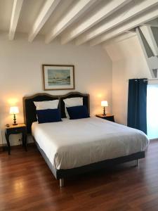 a bedroom with a large bed with blue pillows at Manoir 1685 Saint Malo in Saint Malo
