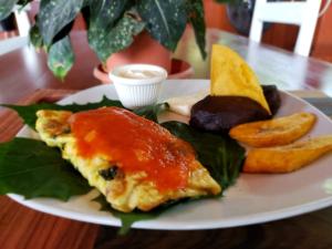 a plate of food with an omelet and other foods at Hotel y Restaurante Las Gardenias in El Remate