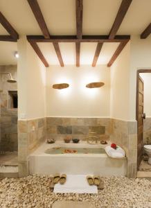 a large bathroom with a tub with shoes on the floor at Dwarika's Resort - Dhulikhel in Dhulikhel