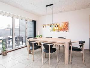 uma sala de jantar com uma mesa de madeira e cadeiras em 8 person holiday home in Bl vand em Blåvand