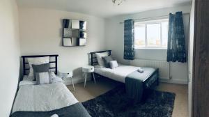 two twin beds in a room with a window at Holiday Home Epworth in Epworth