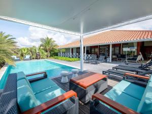 Jan ThielにあるSpacious Villa Near Beachのラウンジチェアとパラソル付きのスイミングプールを併設しています。