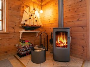 ホにある4 person holiday home in Bl vandの木製の壁の部屋の暖炉