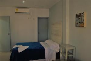 a bedroom with a blue bed and a table at Hotel Castillo Plaza in Ríohacha