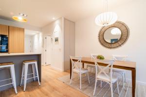 a kitchen and dining room with a table and chairs at Liberty Suites by Santiago with AC in San Sebastián