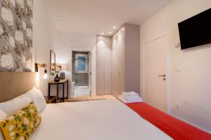 a bedroom with a large white bed and a television at Liberty Suites by Santiago with AC in San Sebastián