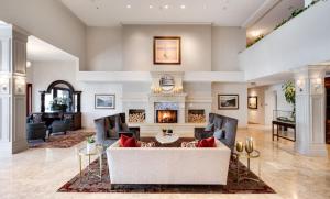 コスタメサにあるAyres Hotel Costa Mesa Newport Beachのソファと暖炉のあるリビングルーム