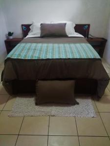 a bed with two pillows on top of a rug at Casa Morella in Monteverde Costa Rica