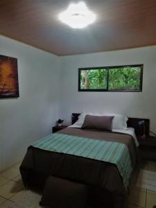 a bedroom with a bed and two windows at Casa Morella in Monteverde Costa Rica