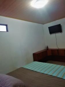 um quarto com uma cama e uma televisão de ecrã plano em Villa Morella em Monteverde