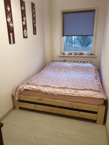 - un petit lit dans une chambre avec fenêtre dans l'établissement Apartament Hoża, à Szczecin