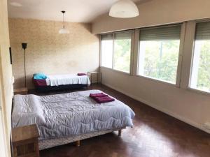 a bedroom with two beds and two windows at Casa Compartida Barranca Yaco - Habit privadas in Córdoba