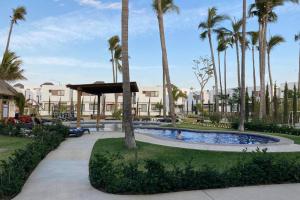 a swimming pool in a resort with palm trees at Preciosa Enjoyable Casa 12 Personas Alberca Playa Coto 24H in Mazatlán