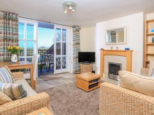 a living room with a fireplace and a television at 14 Combehaven in Salcombe