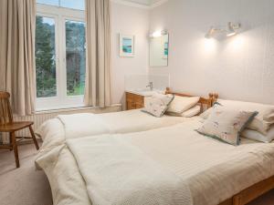 a bedroom with two beds and a window at 1 Hazeldene in Salcombe