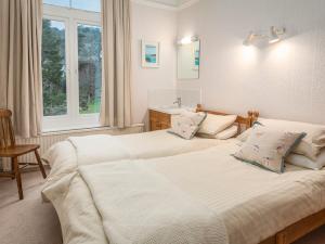 ein Schlafzimmer mit zwei Betten und einem Fenster in der Unterkunft 1 Hazeldene in Salcombe