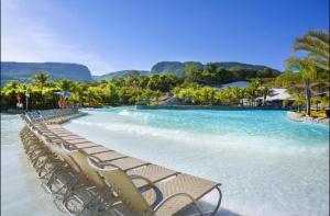 - une rangée de chaises sur une plage d'eau bleue dans l'établissement Hotel Giardino Rio Quente Apartamento Dúplex Cobertura 627-P, à Rio Quente