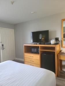 a bedroom with a bed and a flat screen tv at Tulip Inn Mount Vernon in Mount Vernon