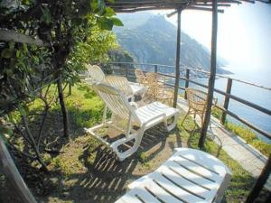 a group of chairs sitting on a balcony overlooking the water at Hotel Gianni Franzi in Vernazza